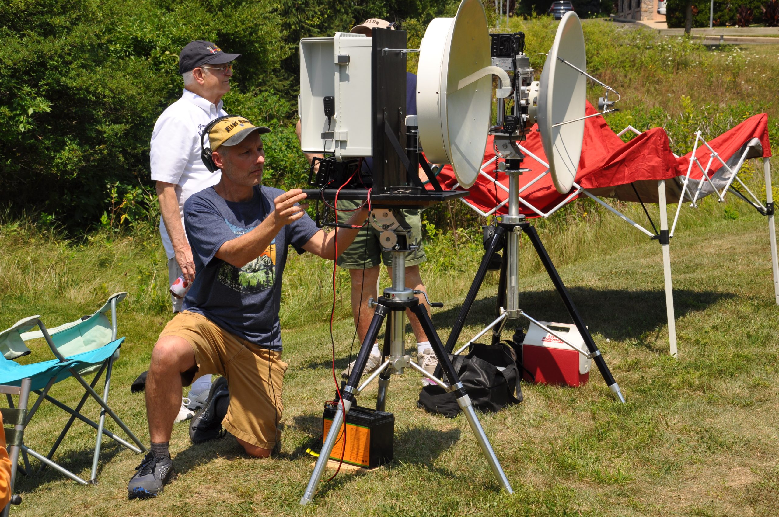 Andy KF3Y kneeling and adjusting a 10 GHz dish and horn setup
