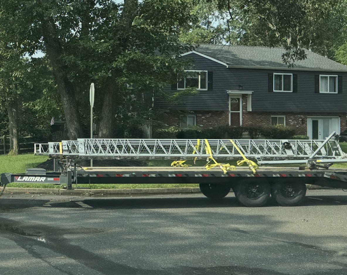 Tower sections strapped flat to a Lamar flatbed trailer, ready for the fifteen-mile drive